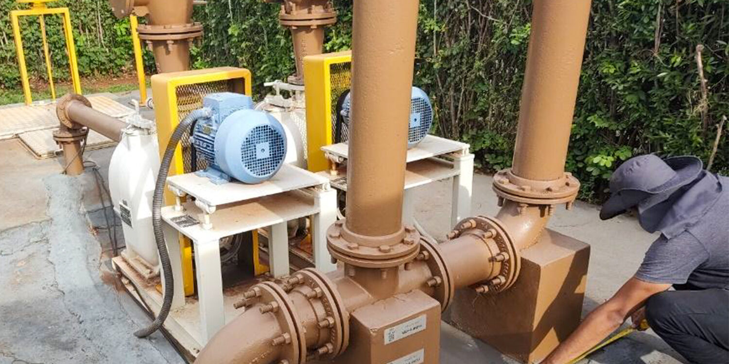 Técnico medindo tubulações e bombas de uma estação elevatória