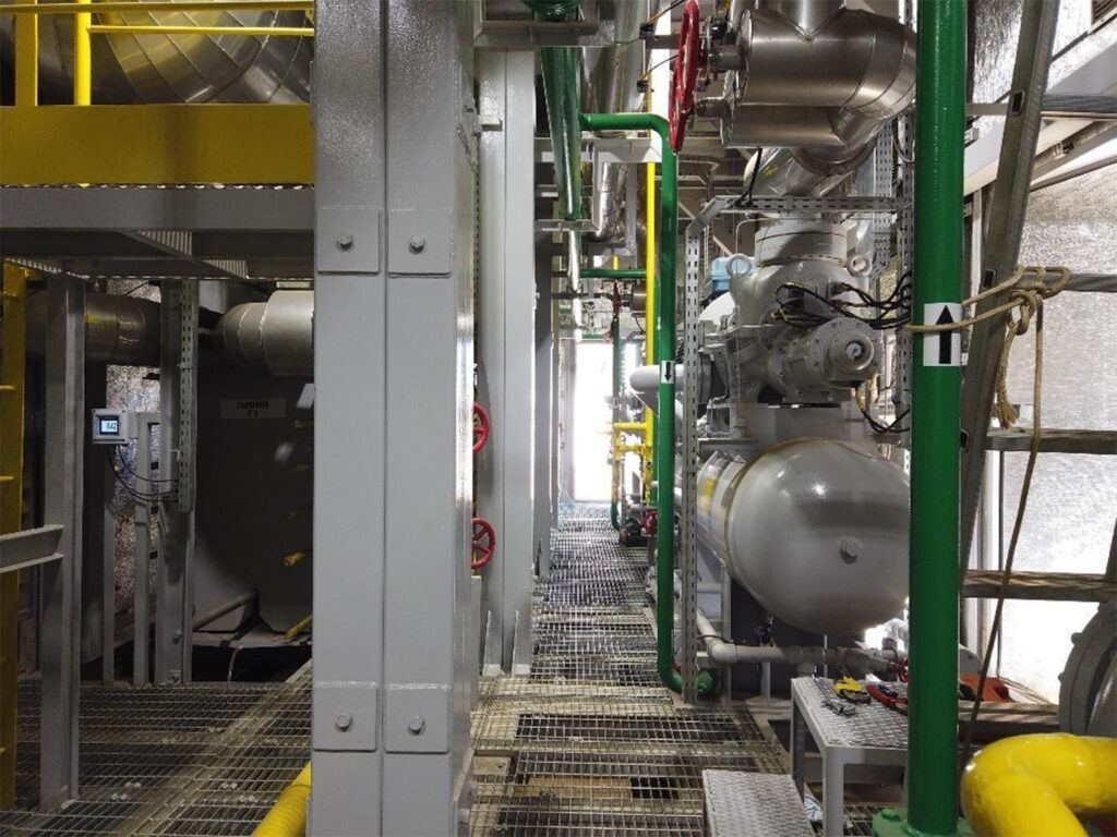Interior de planta de refrigeração industrial com tubulações e equipamentos