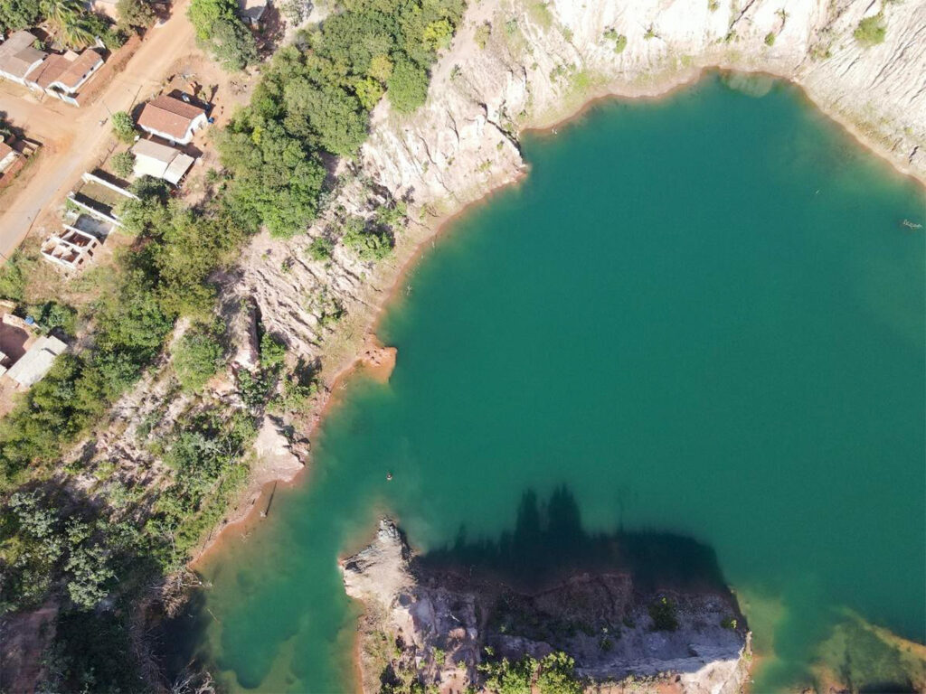 Vista aérea de cava de mineração com água acumulada e paredes rochosas