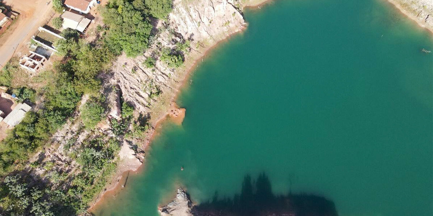 Vista aérea de cava de mineração com água acumulada e paredes rochosas
