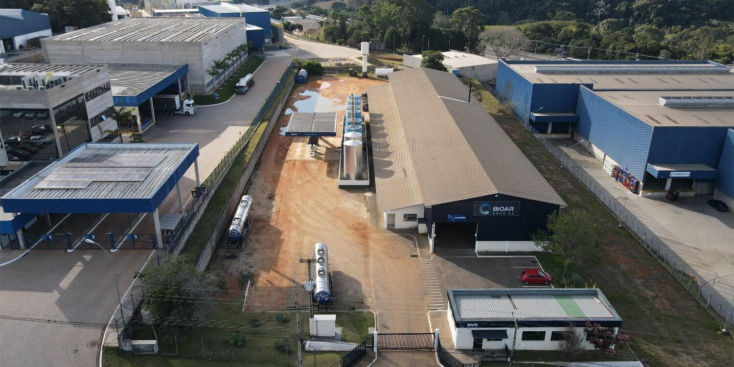 Vista aérea de unidade industrial com galpões e pátio de manobras