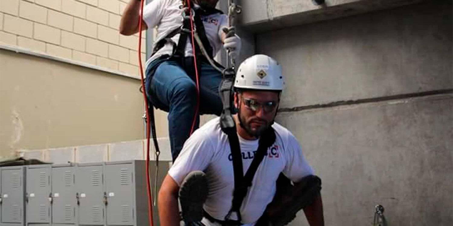 Profissionais em treinamento de trabalho em altura com resgate por cordas
